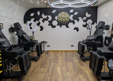 Sleek tattoo studio interior at Organic Joy Tattoo, Dublin, County Dublin, IE with modern decor and adjustable chairs.