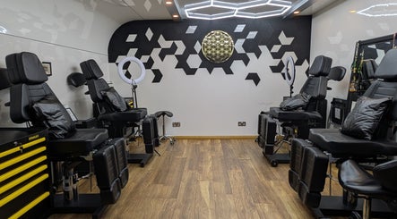 Sleek tattoo studio interior at Organic Joy Tattoo, Dublin, County Dublin, IE with modern decor and adjustable chairs.