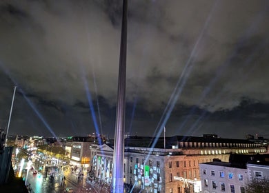Cityscape view from Organic Joy Tattoo, Dublin, County Dublin, IE at night with illuminated buildings and art installation.