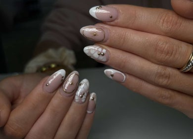 Stylish nail designs at Nails By Mya, Blantyre, Scotland, GB showcasing intricate white and gold accents.