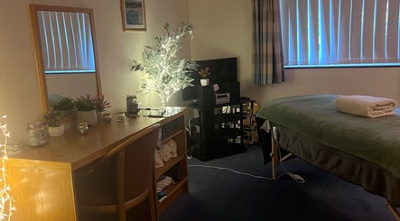 Cozy therapy room at Pure Massage Therapy, Newton Abbot, England, GB with massage table and ambient lighting.