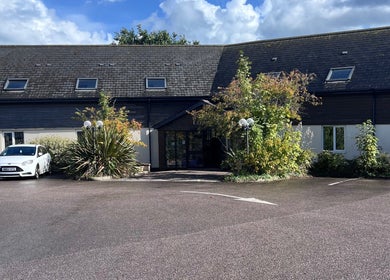 Entrance to Pure Massage Therapy in Newton Abbot, England, surrounded by greenery.