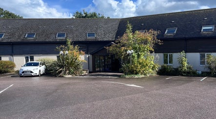 Entrance to Pure Massage Therapy in Newton Abbot, England, surrounded by greenery.