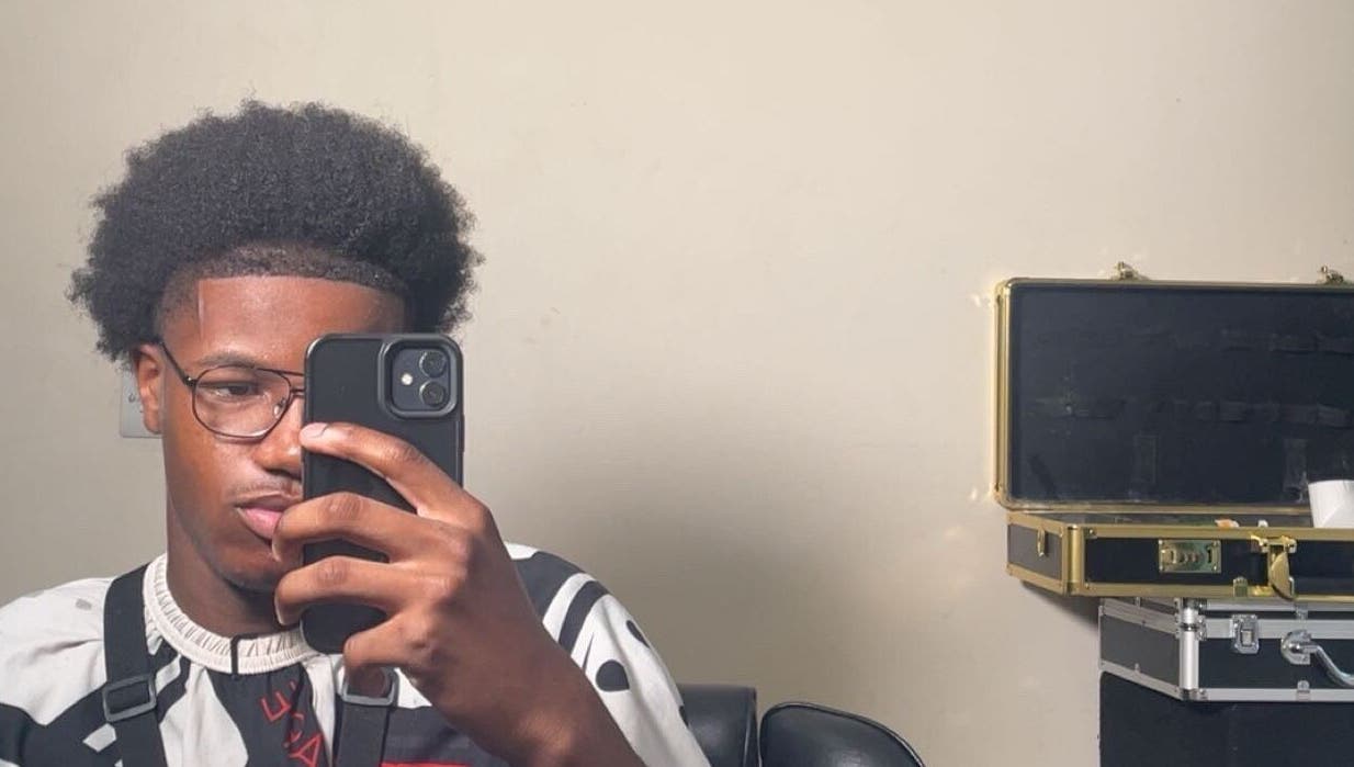 Stylish haircut at LMBlendz, Birmingham, England, GB. Young man with an afro and glasses taking a selfie.