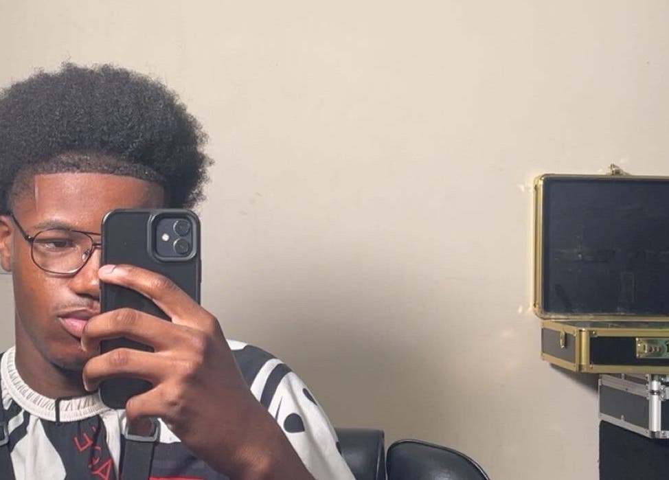 Stylish haircut at LMBlendz, Birmingham, England, GB. Young man with an afro and glasses taking a selfie.