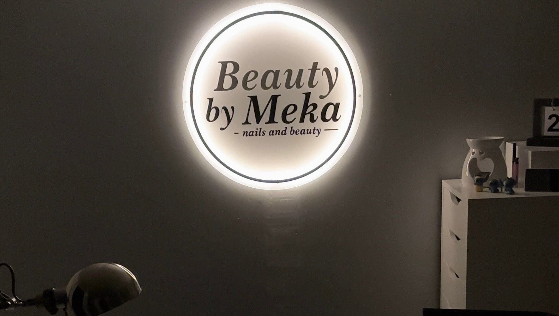 Illuminated logo of Beauty by Meka - Home Salon, Kirkcaldy, Scotland, GB, on a dark wall.