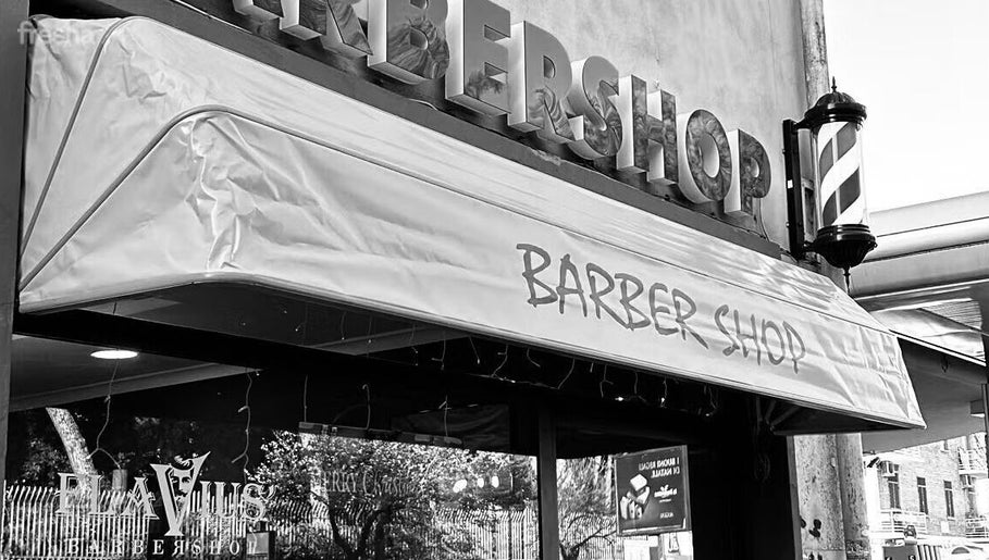 Ingresso del Flavius'Barbershop a Roma, Lazio, IT con insegna del barbiere visibile.