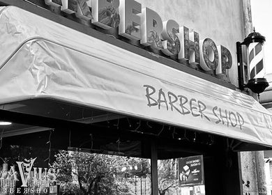 Ingresso del Flavius'Barbershop a Roma, Lazio, IT con insegna del barbiere visibile.
