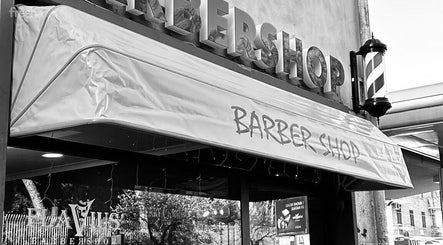 Ingresso del Flavius'Barbershop a Roma, Lazio, IT con insegna del barbiere visibile.
