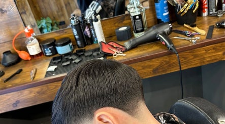 Taglio di capelli moderno a Flavius’ Barbershop, Roma, Lazio, IT. Strumenti da barbiere sullo sfondo.