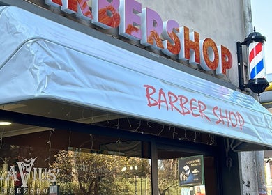 Insegna di Flavius’ Barbershop Tuscolana, Roma, Lazio, IT, con caratteristico palo da barbiere.