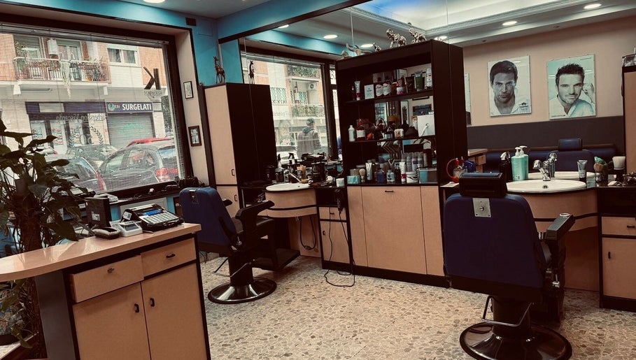Interno moderno di Flavius’Barbershop a Roma, Lazio, IT, mostra poltrone e attrezzatura da barbiere.