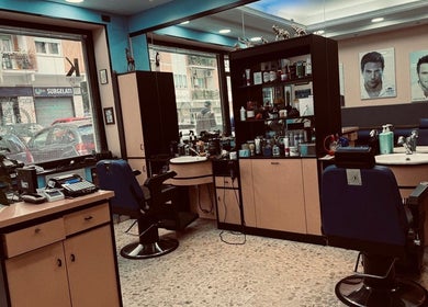 Interno moderno di Flavius’Barbershop a Roma, Lazio, IT, mostra poltrone e attrezzatura da barbiere.