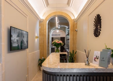 Reception area of Amis City Spa, Beauty & Hair Salon in Il-belt Valletta, MT with elegant decor and fresh flowers.