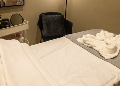 Relaxing massage room at Amis City Spa, Beauty & Hair Salon in Il-belt Valletta, MT with a neatly arranged bed.