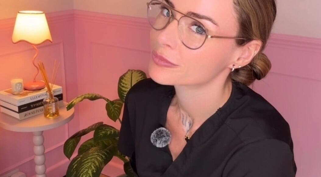 Woman in stylish glasses at Heartbreaker Aesthetics, Henfield, England, GB, relaxes in a chic corner.