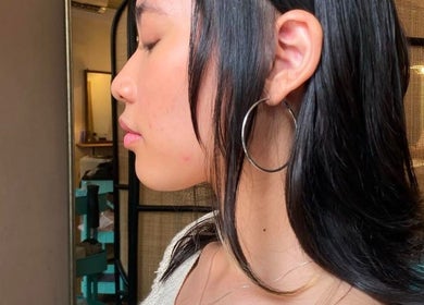 Elegant hairstyle at Dee Hair Studio, Johor Bahru, Johor, MY, showcasing sleek black hair and stylish hoop earrings.
