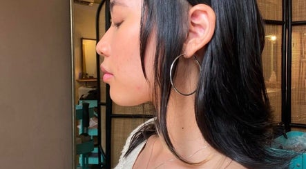 Elegant hairstyle at Dee Hair Studio, Johor Bahru, Johor, MY, showcasing sleek black hair and stylish hoop earrings.