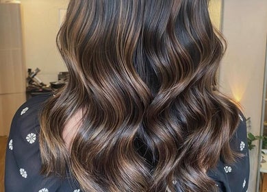 Elegant wavy hairstyle at Dee Hair Studio in Johor Bahru, Johor, MY, highlighting vibrant color and shine.