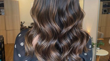 Elegant wavy hairstyle at Dee Hair Studio in Johor Bahru, Johor, MY, highlighting vibrant color and shine.