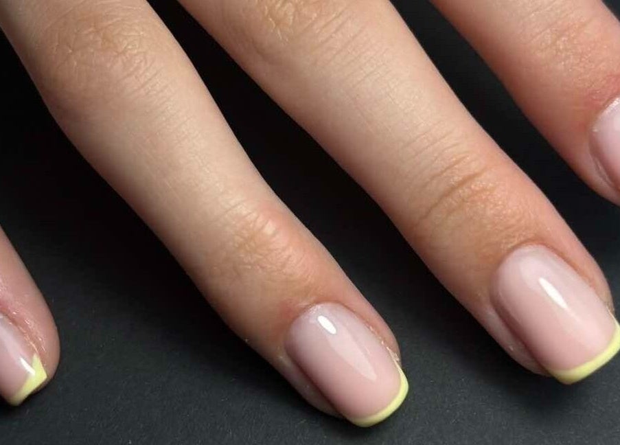 Verzorgde nagelsessie bij MORRI, Sint-niklaas, Vlaams Gewest, BE, met zachte roze en gele tint.