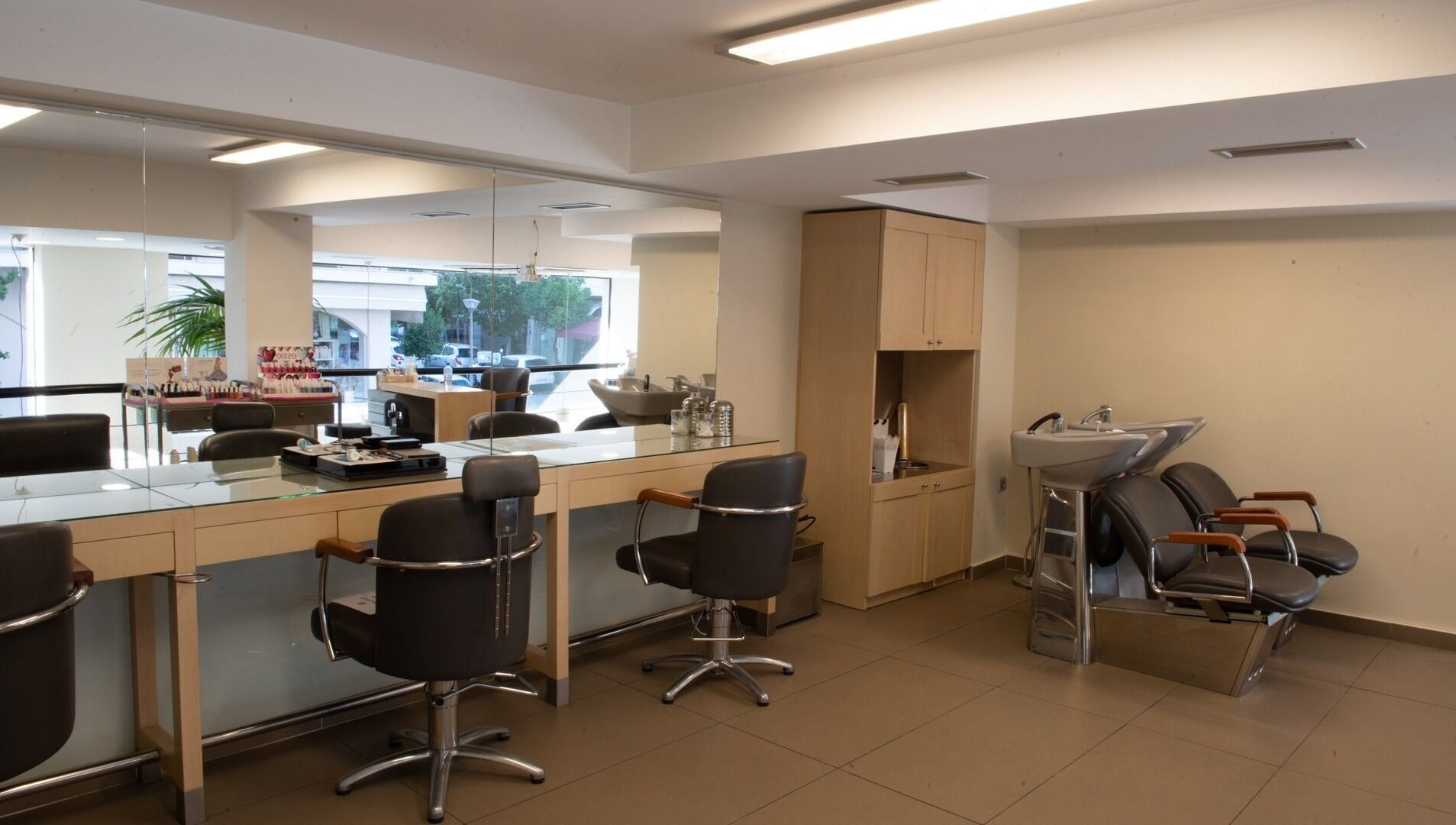 Εσωτερικό κομμωτηρίου Helena Milanou Αιγάλεω με μοντέρνα καθίσματα και καθρέφτες στο Αιγάλεω, GR.