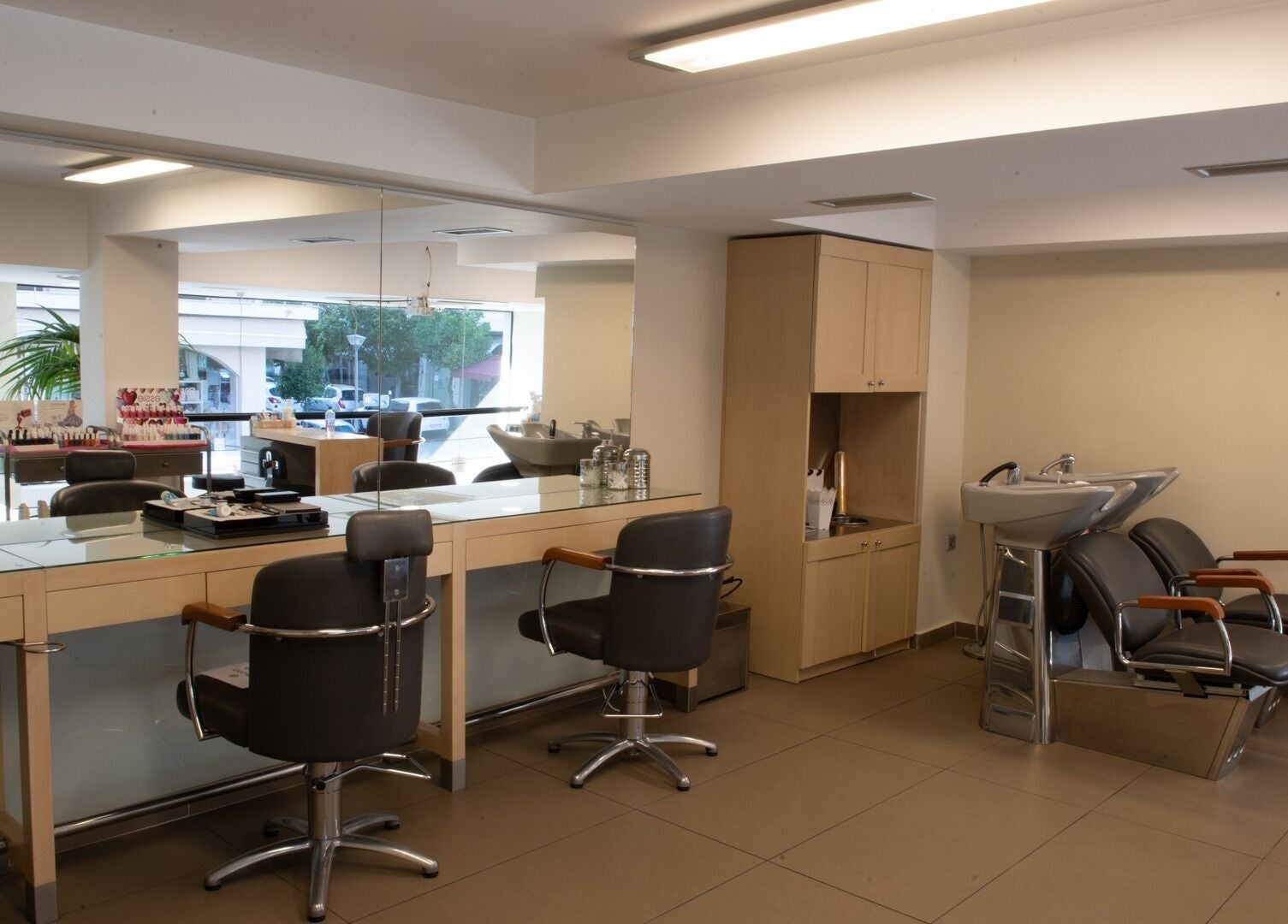 Εσωτερικό κομμωτηρίου Helena Milanou Αιγάλεω με μοντέρνα καθίσματα και καθρέφτες στο Αιγάλεω, GR.