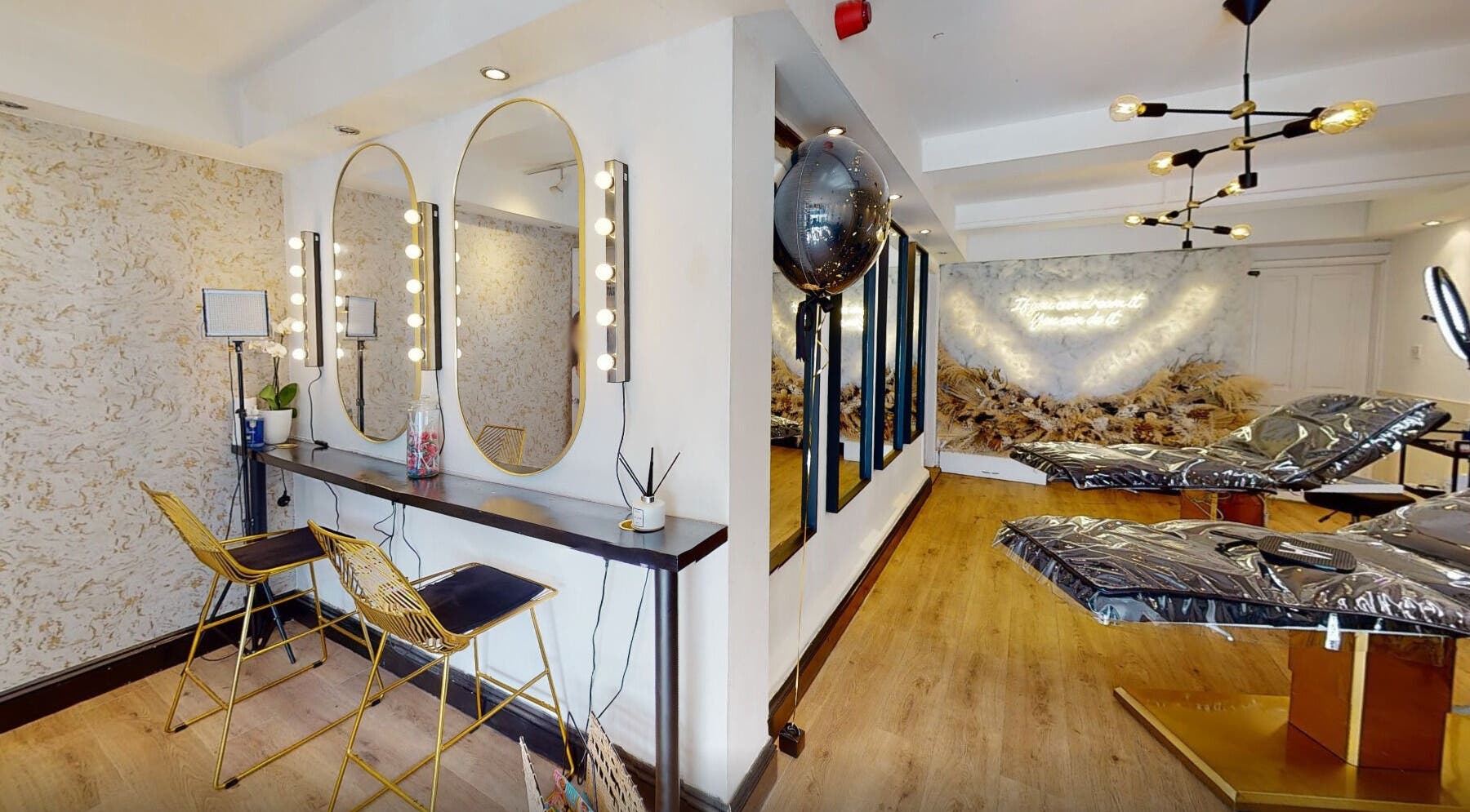 Chic interior of Mi Amor Aesthetics, Derby, England. Features sleek mirrors, modern chairs, and ambient lighting.