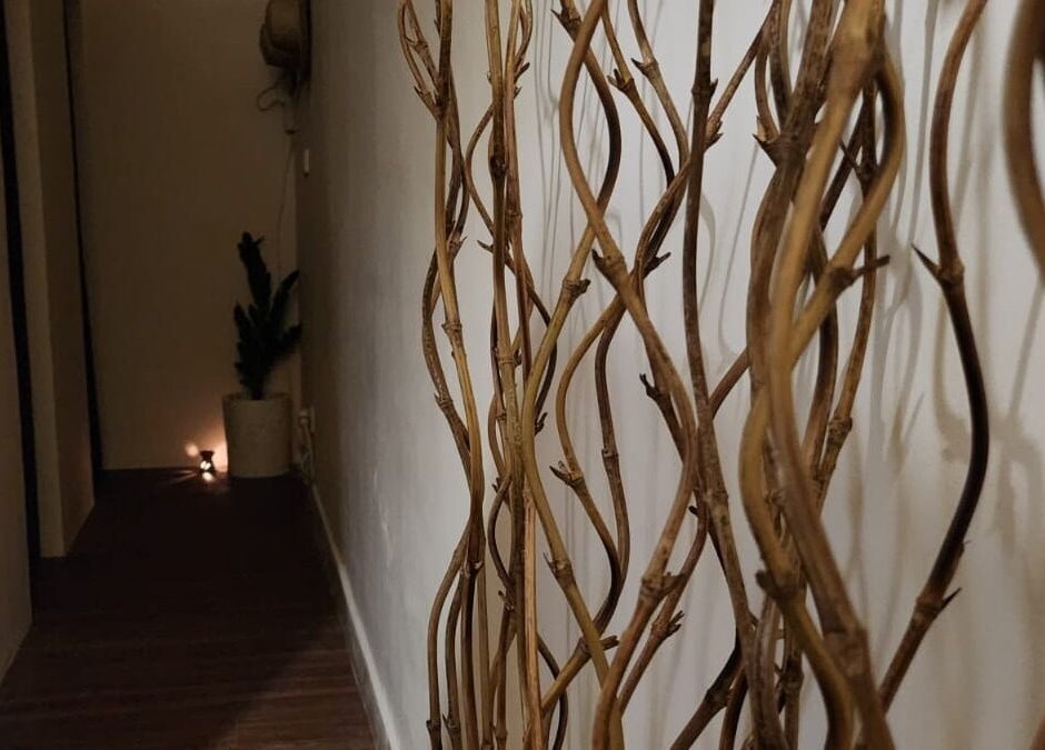 Dimly lit hallway with decorative sticks at Khonó Spa, Bali, Bali, ID offering a tranquil ambiance.