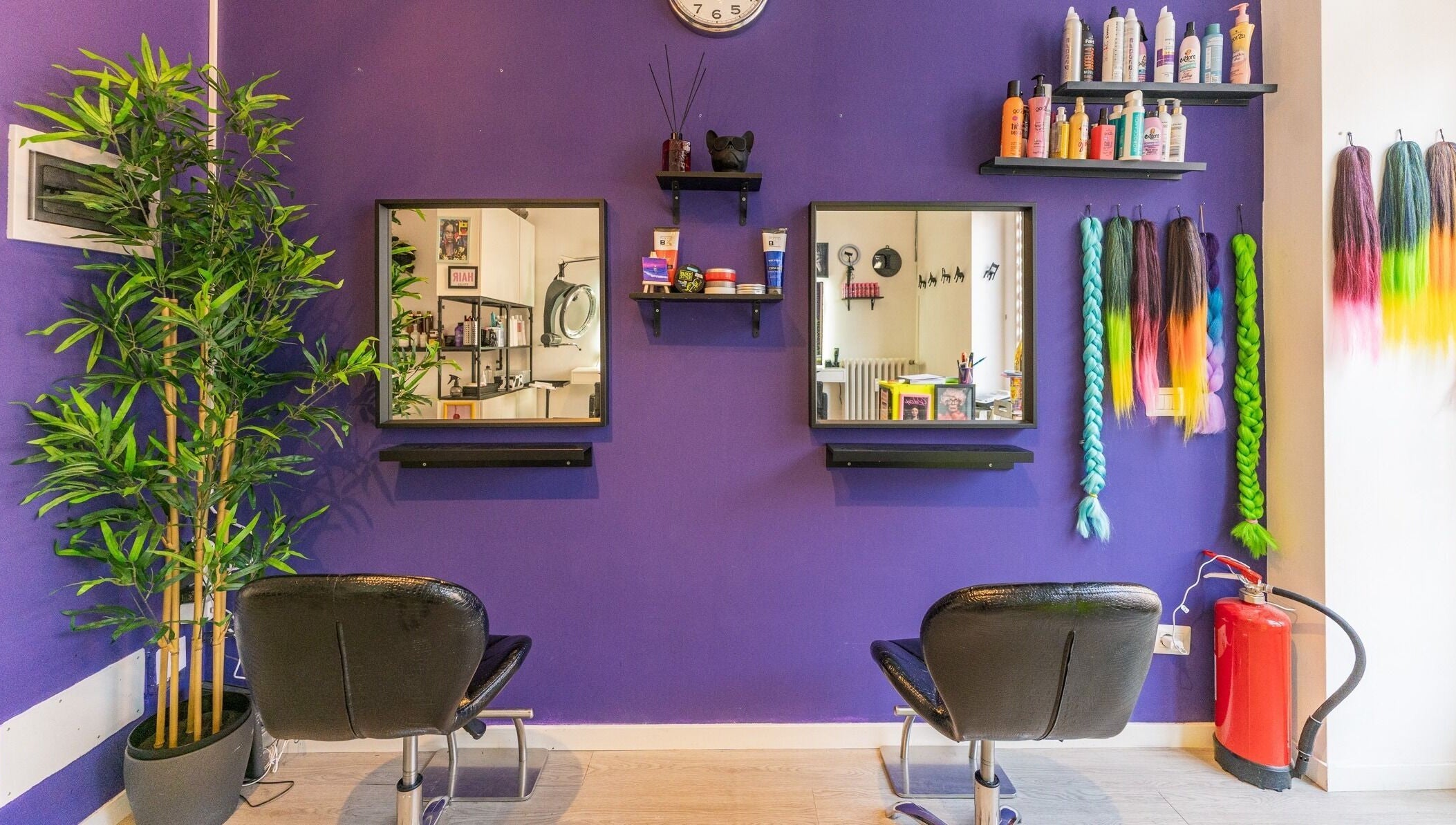 Interno vivace del salone Room17 a Milano, Lombardia, IT con sedie nere e parete viola decorativa.