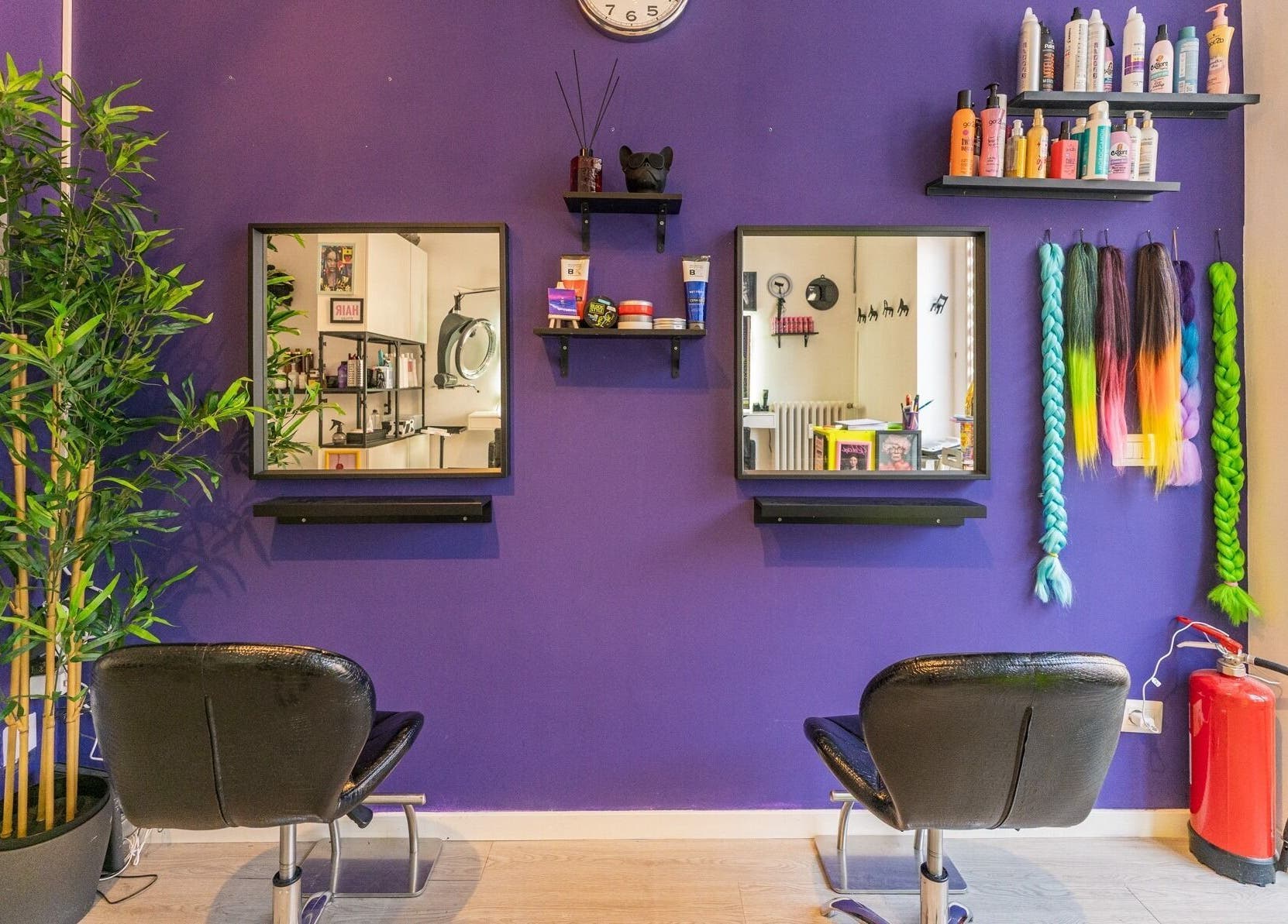 Interno vivace del salone Room17 a Milano, Lombardia, IT con sedie nere e parete viola decorativa.