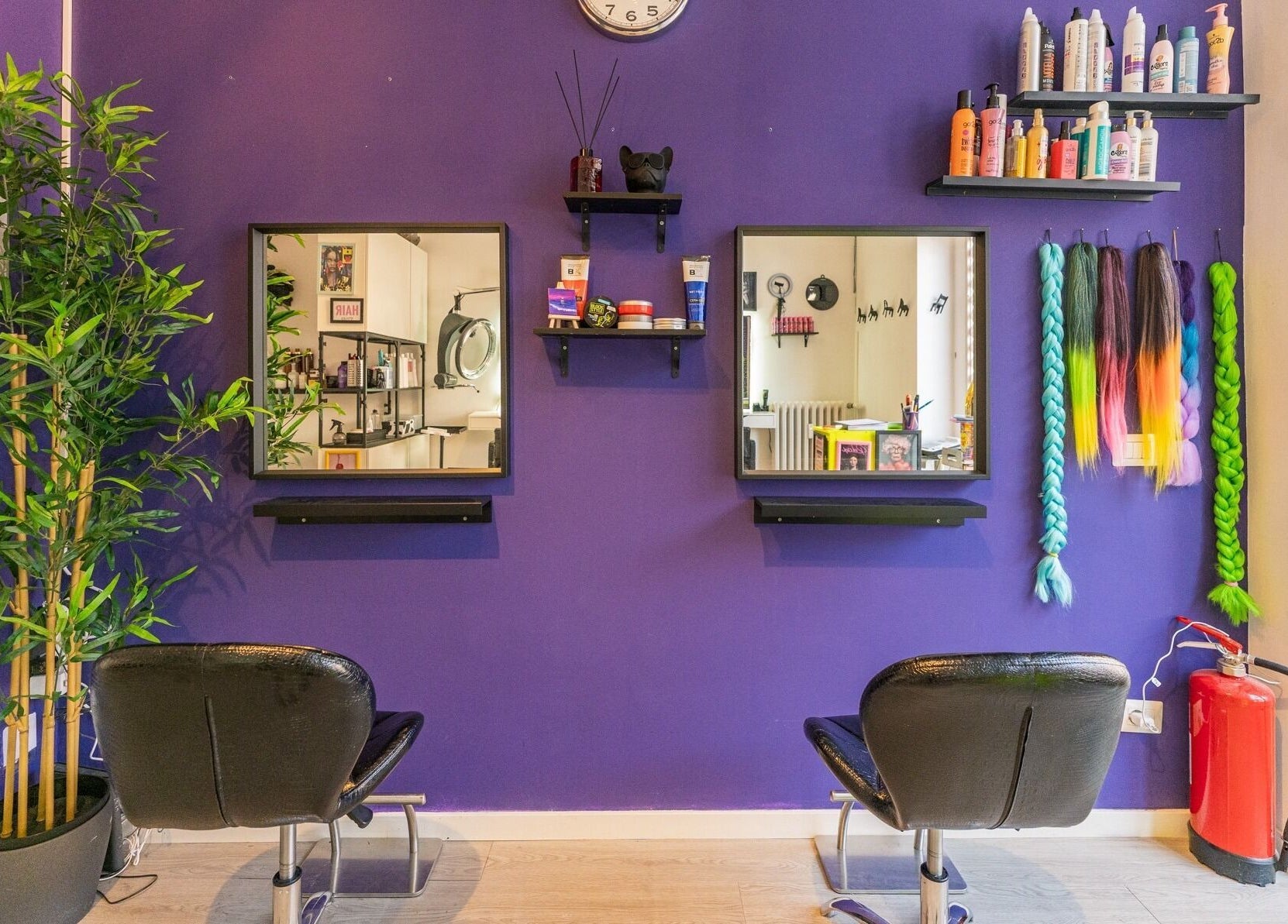 Interno vivace del salone Room17 a Milano, Lombardia, IT con sedie nere e parete viola decorativa.