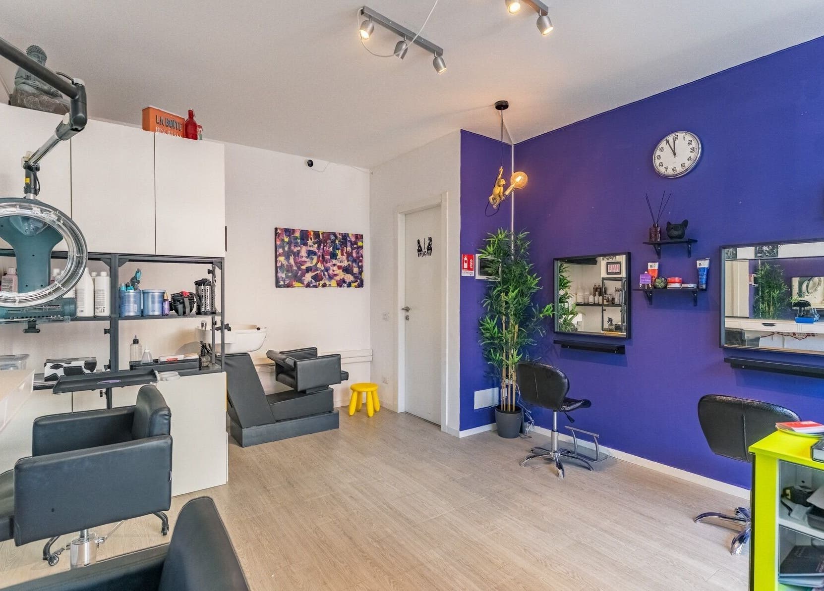 Interno di Room17 a Milano, Lombardia, IT. Arredamento moderno con pareti viola e postazioni di bellezza.