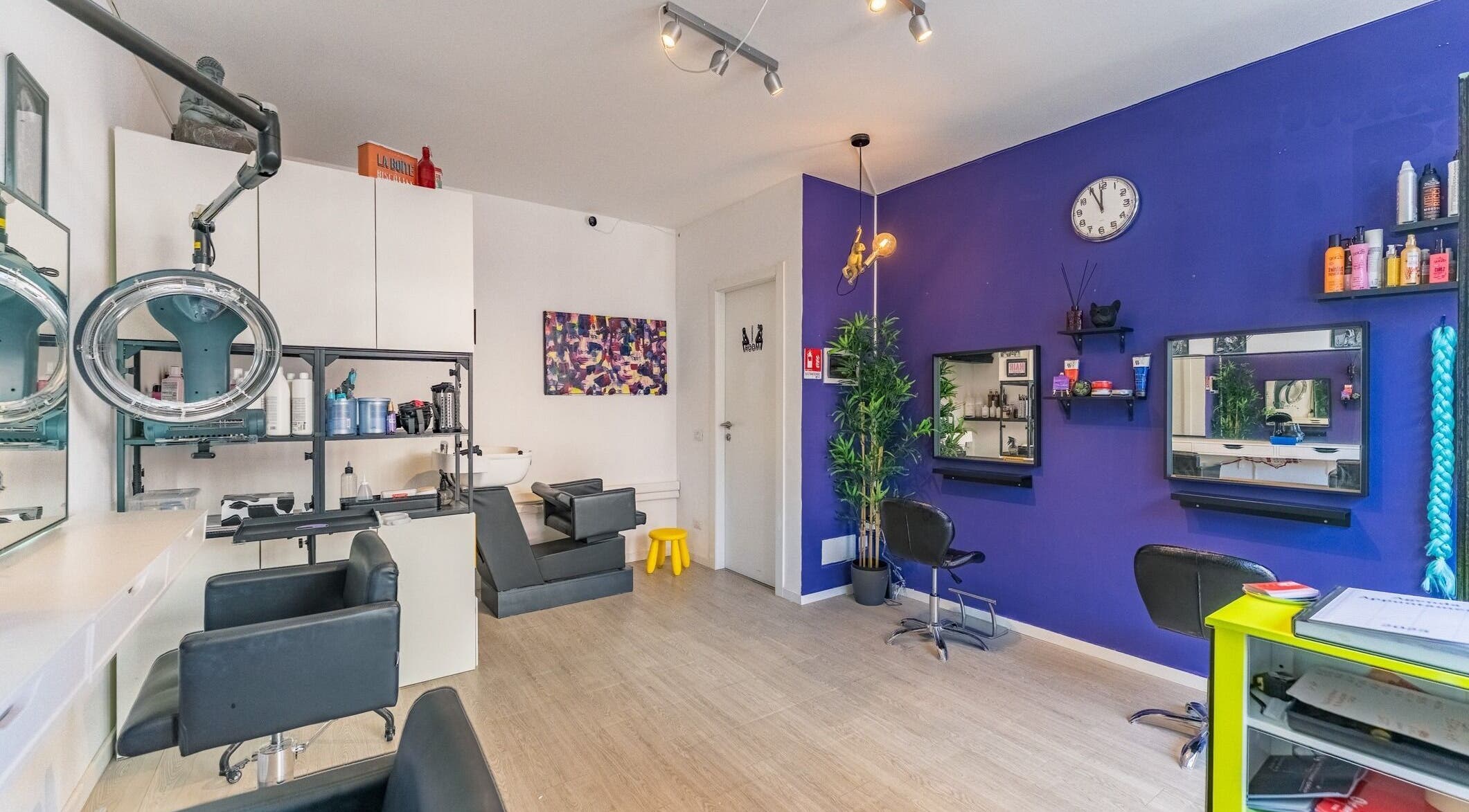 Interno di Room17 a Milano, Lombardia, IT. Arredamento moderno con pareti viola e postazioni di bellezza.