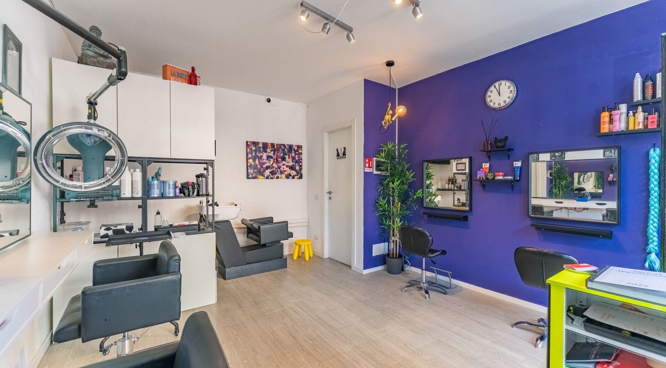 Interno di Room17 a Milano, Lombardia, IT. Arredamento moderno con pareti viola e postazioni di bellezza.