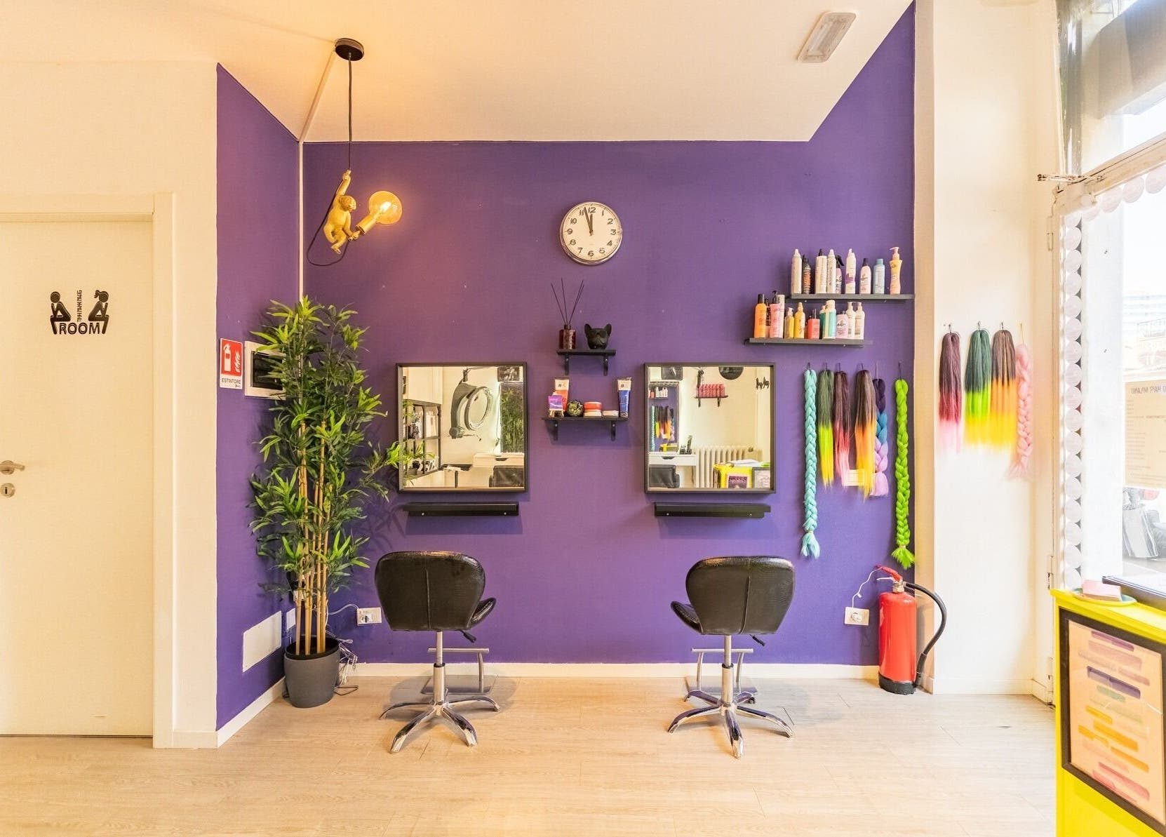 Interno moderno di Room17 a Milano, Lombardia, IT, con pareti viola e poltrone nere.