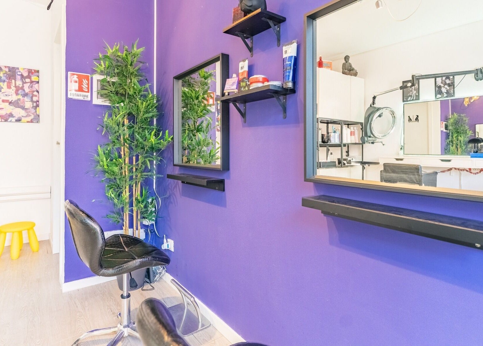 Interno moderno di Room17, Milano, Lombardia, IT, con pareti viola, specchi e sedie da parrucchiere.