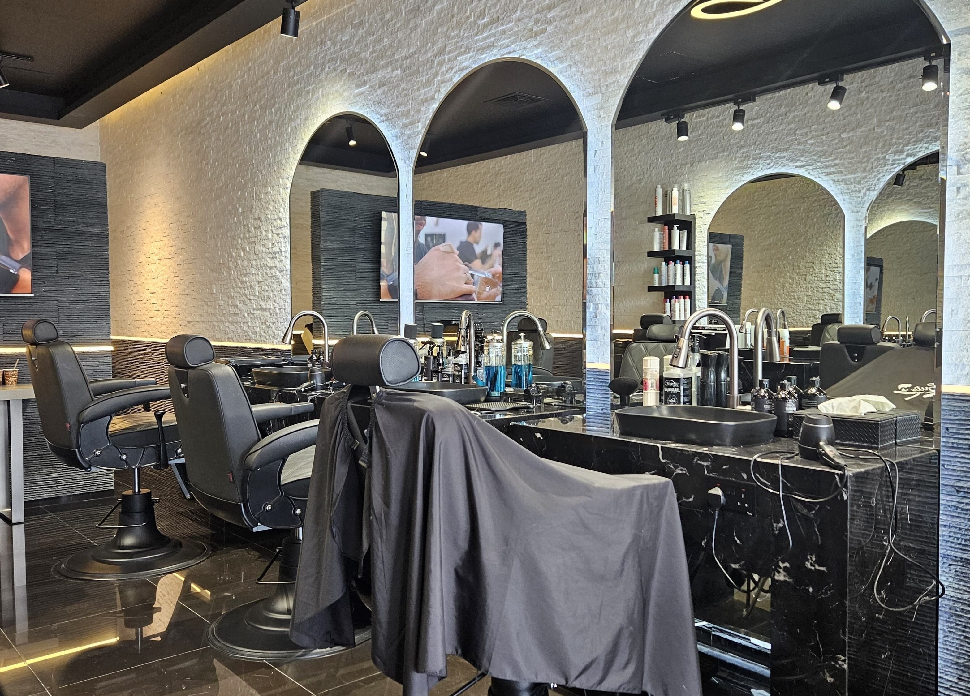 Modern interior of Cuts Gents Salon in Dubai, Dubai, AE with stylish chairs and mirrors.