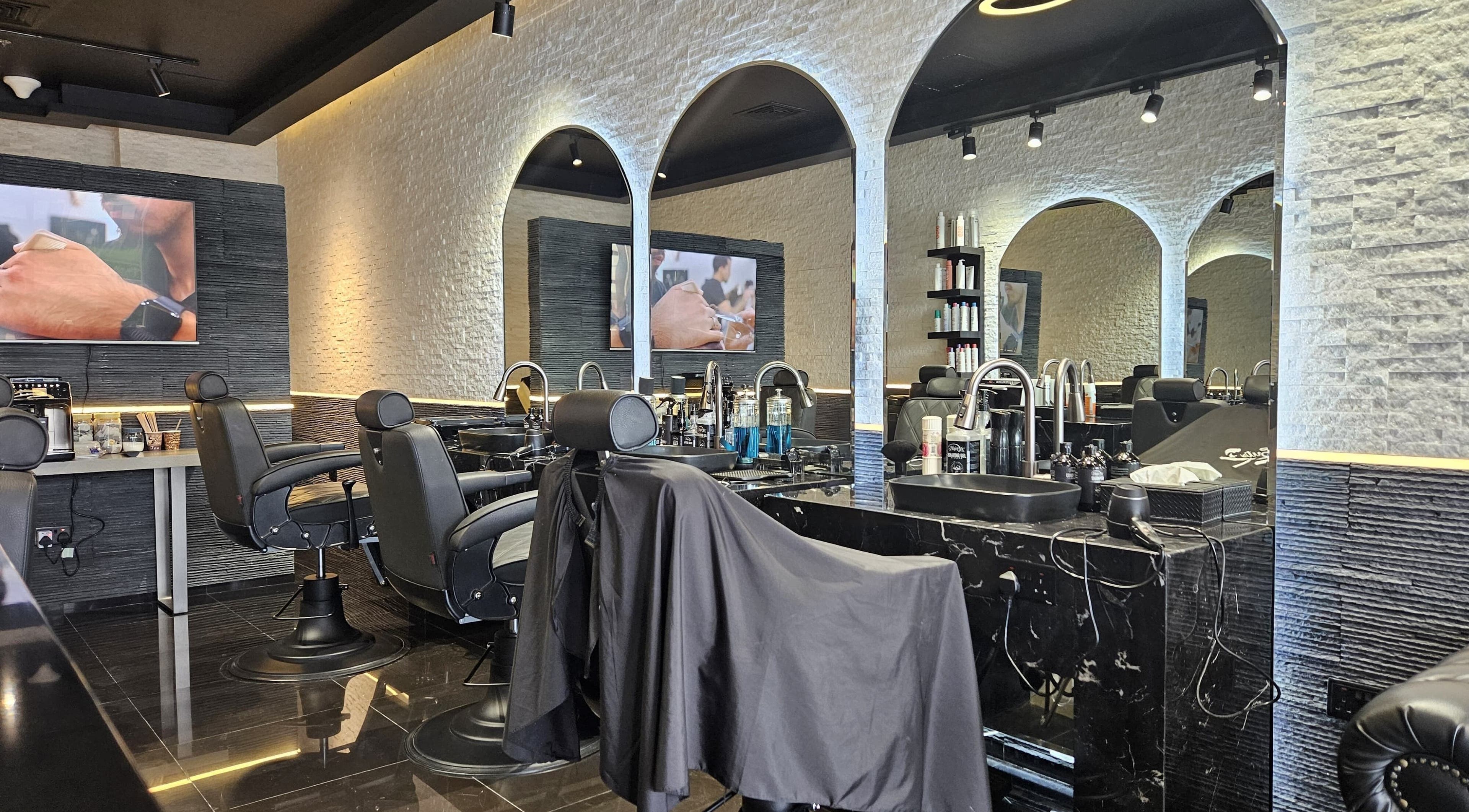 Modern interior of Cuts Gents Salon in Dubai, Dubai, AE with stylish chairs and mirrors.