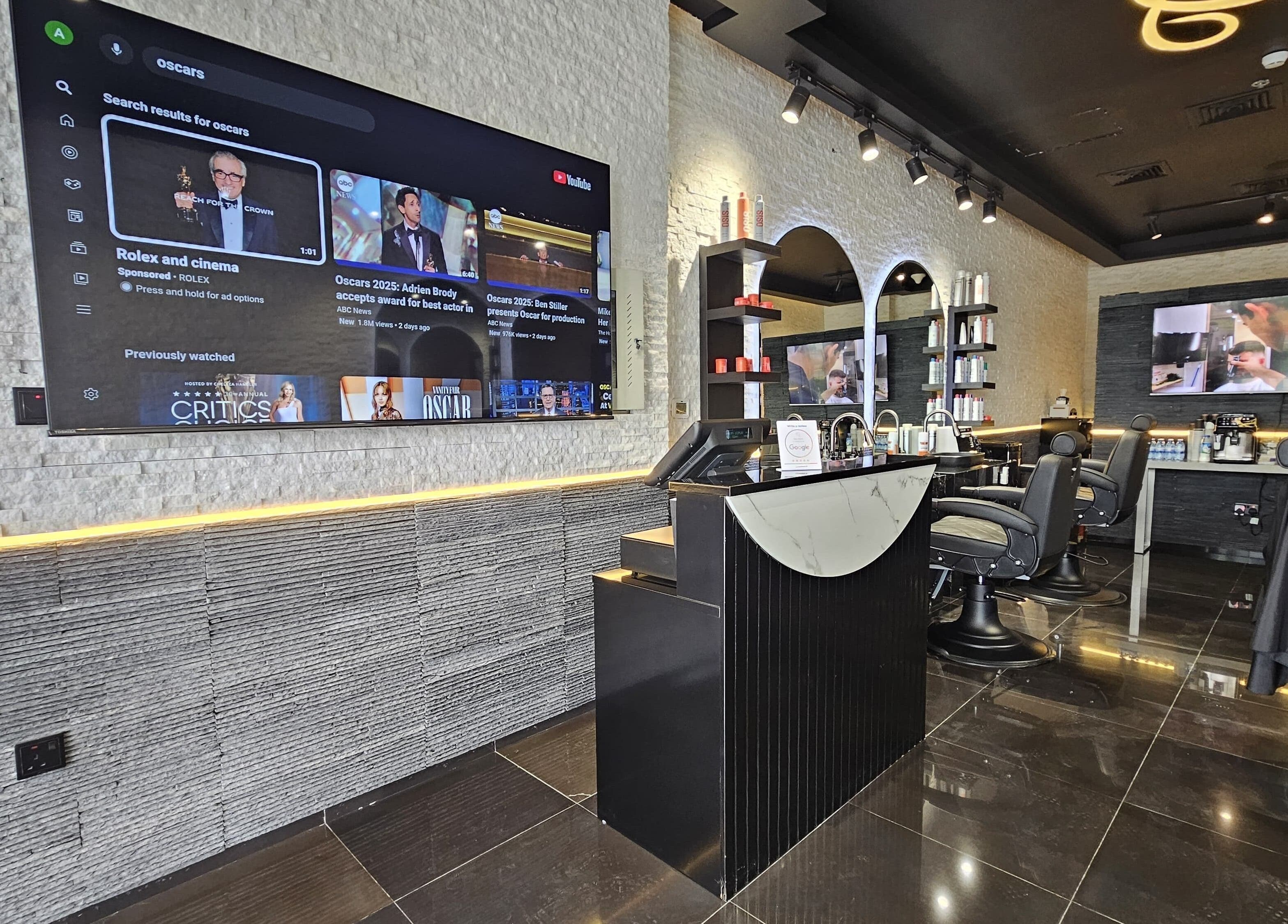 Interior of Cuts Gents Salon in Dubai, Dubai, AE showing sleek modern design with barber chairs and TV screen.
