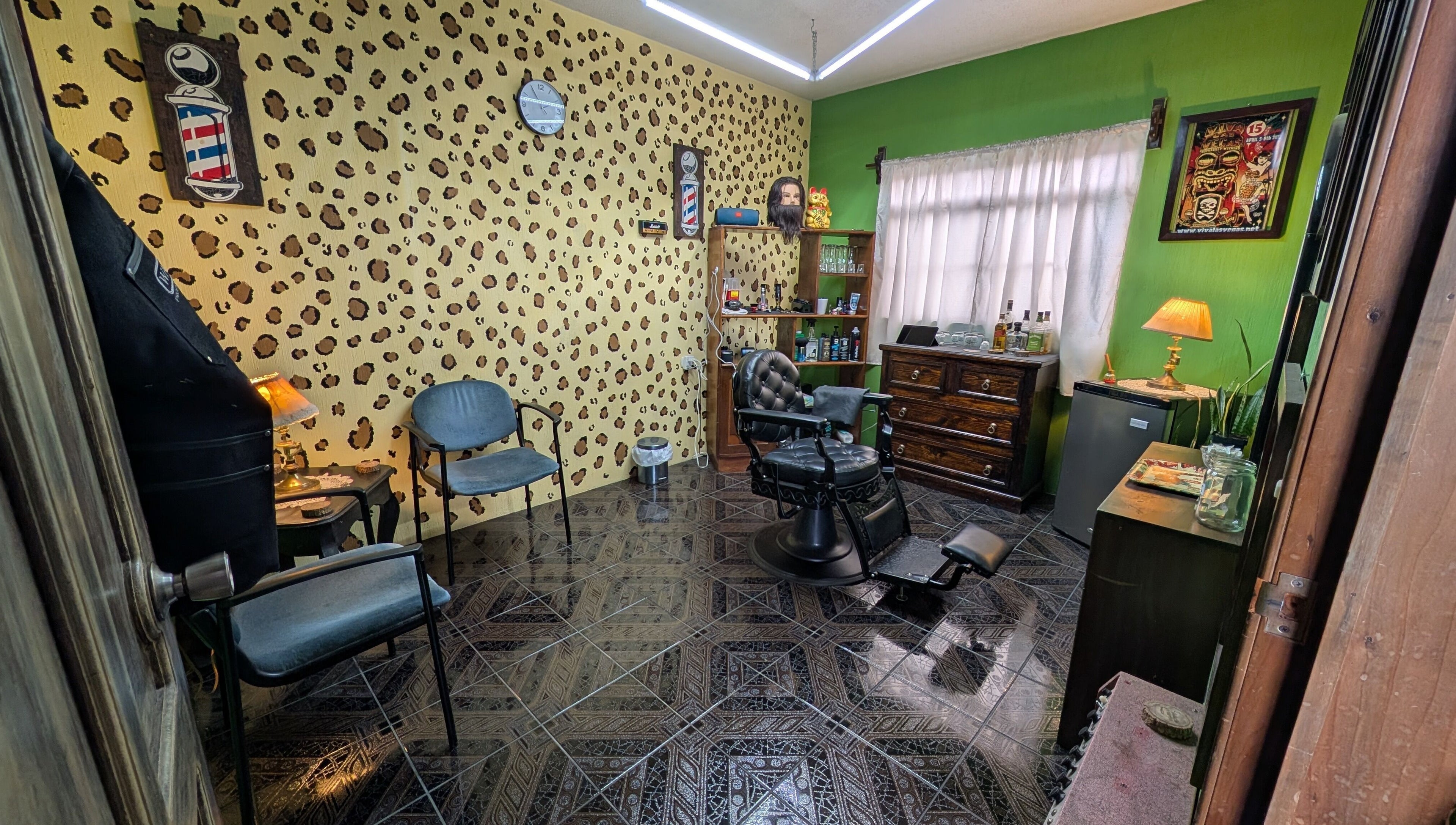 Interior de Jota Ele Barbería en El Tejar, Chimaltenango, GT, con sillón clásico y decoración única.