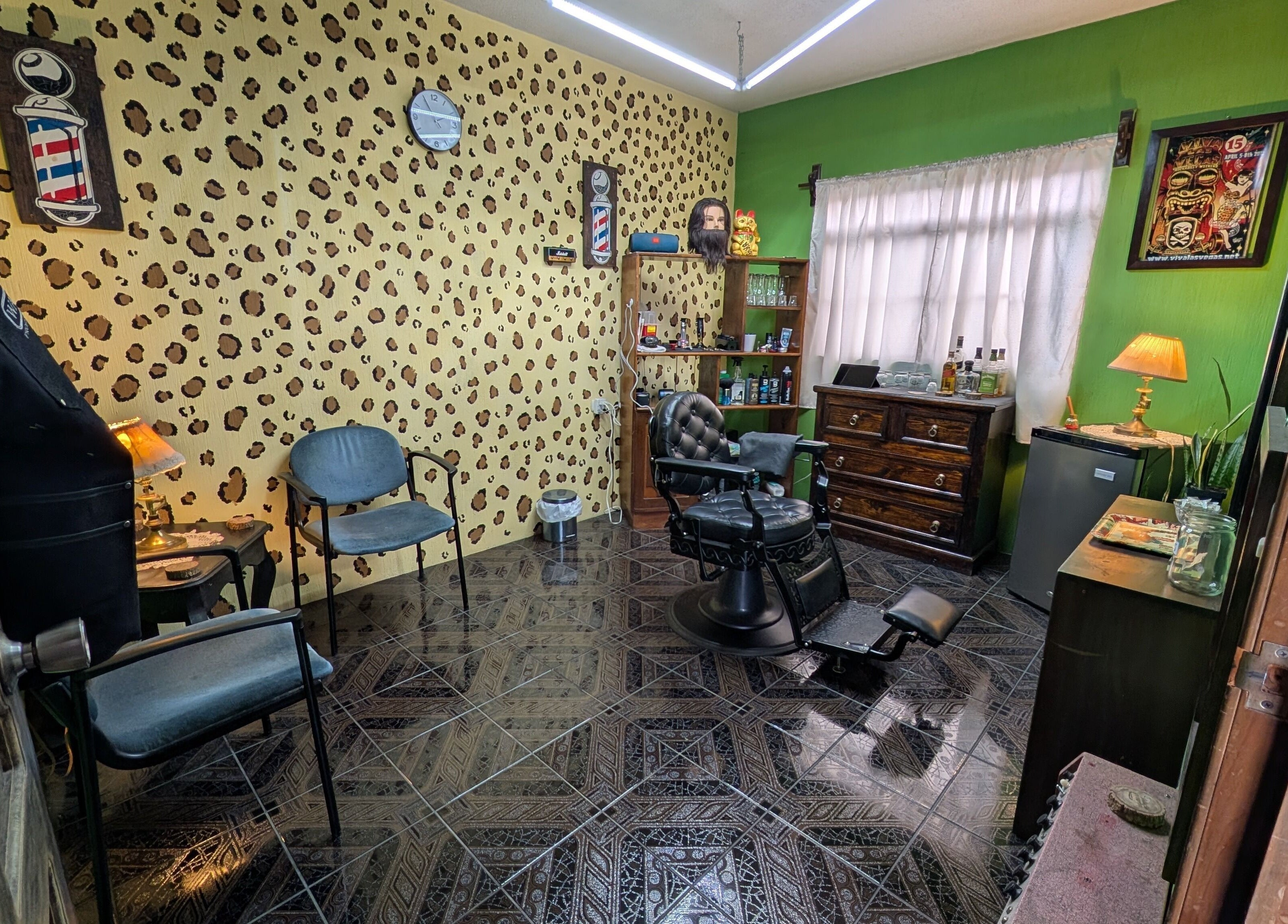 Interior de Jota Ele Barbería en El Tejar, Chimaltenango, GT, con sillón clásico y decoración única.