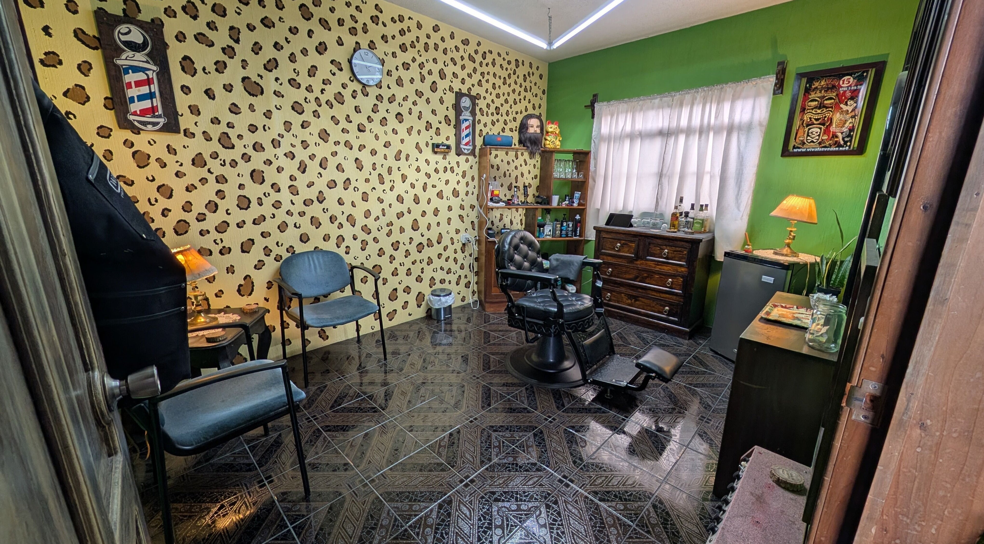 Interior de Jota Ele Barbería en El Tejar, Chimaltenango, GT, con sillón clásico y decoración única.
