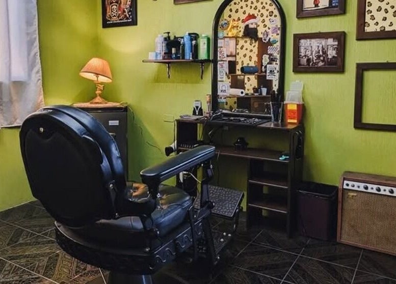 Interior clásico de Jota Ele Barbería en El Tejar, Chimaltenango, GT, con sillón y decoración retro.