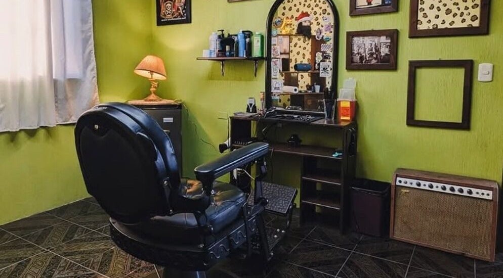 Interior clásico de Jota Ele Barbería en El Tejar, Chimaltenango, GT, con sillón y decoración retro.