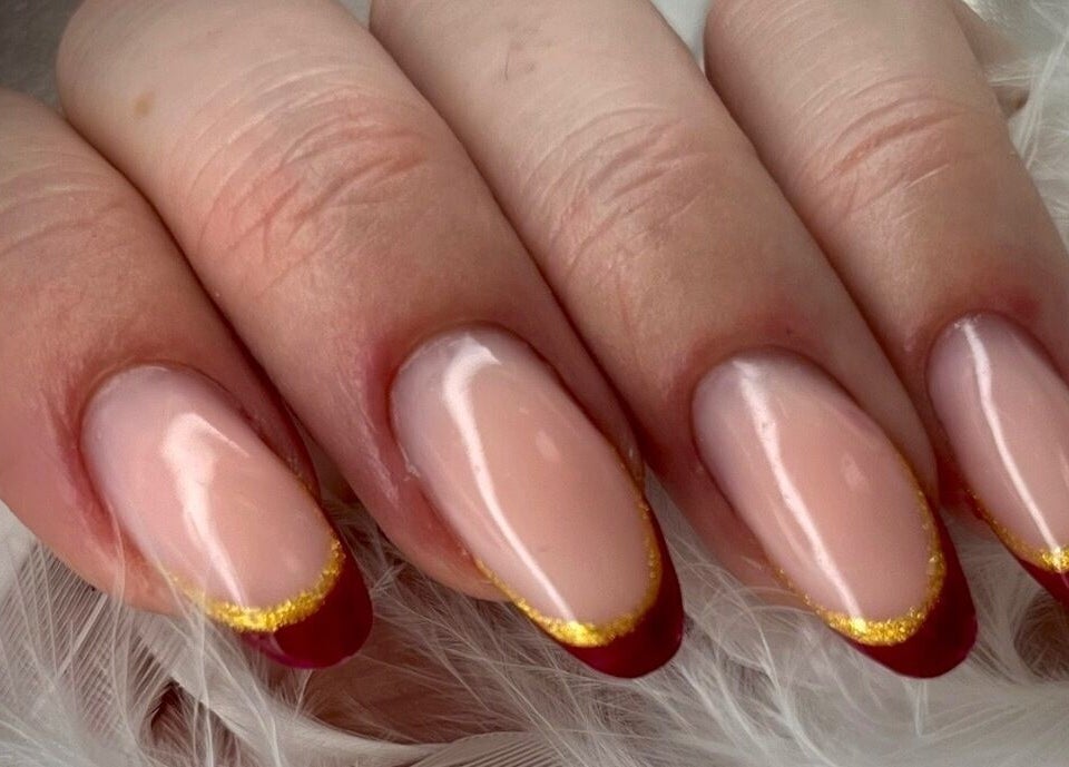 Manucure élégante chez Dynails à Montmacq, Hauts-de-france, FR avec finition rouge et or.