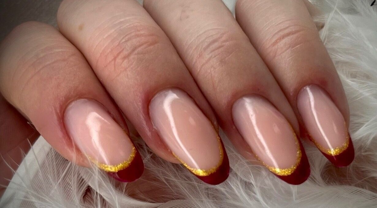 Manucure élégante chez Dynails à Montmacq, Hauts-de-france, FR avec finition rouge et or.