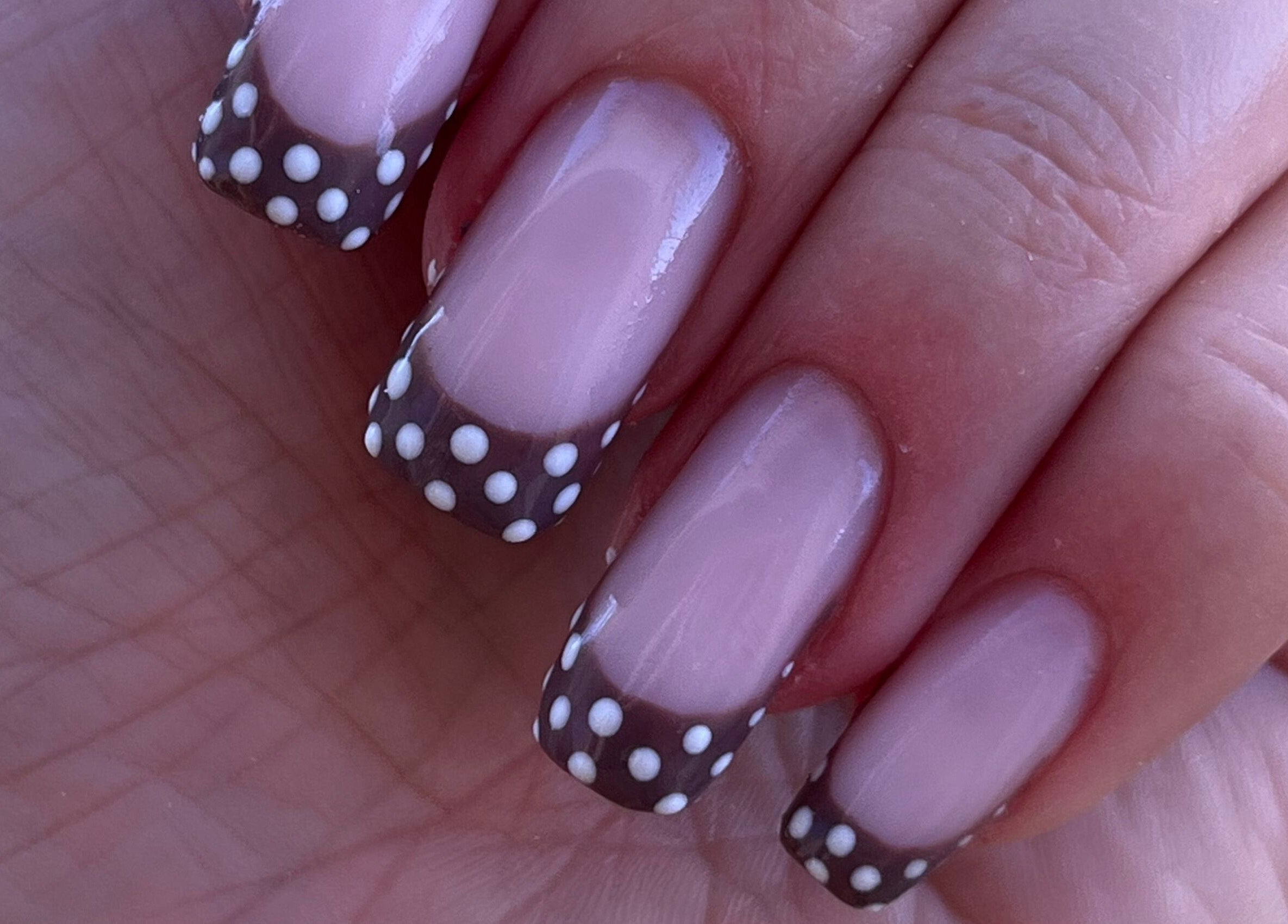 Manucure à pois blancs sur ongles au salon Dynails, Montmacq, Hauts-de-France, FR.