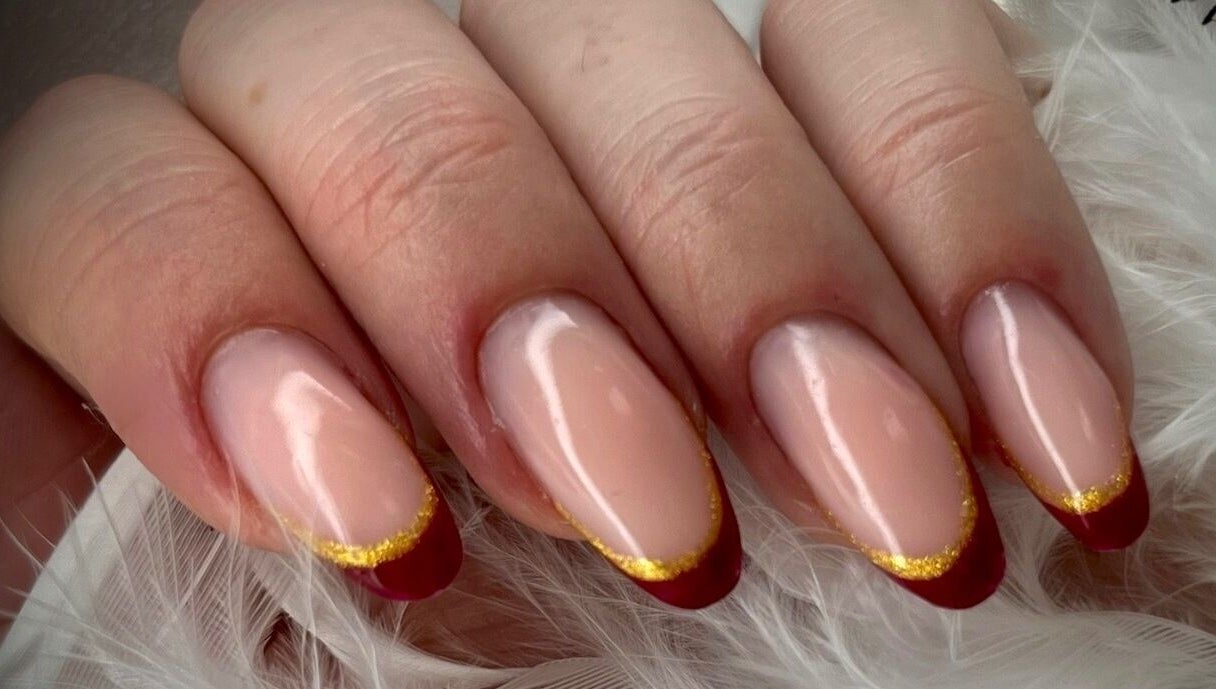 Manucure élégante Dynails à Montmacq, Hauts-de-France, FR avec vernis rouge et doré brillant.