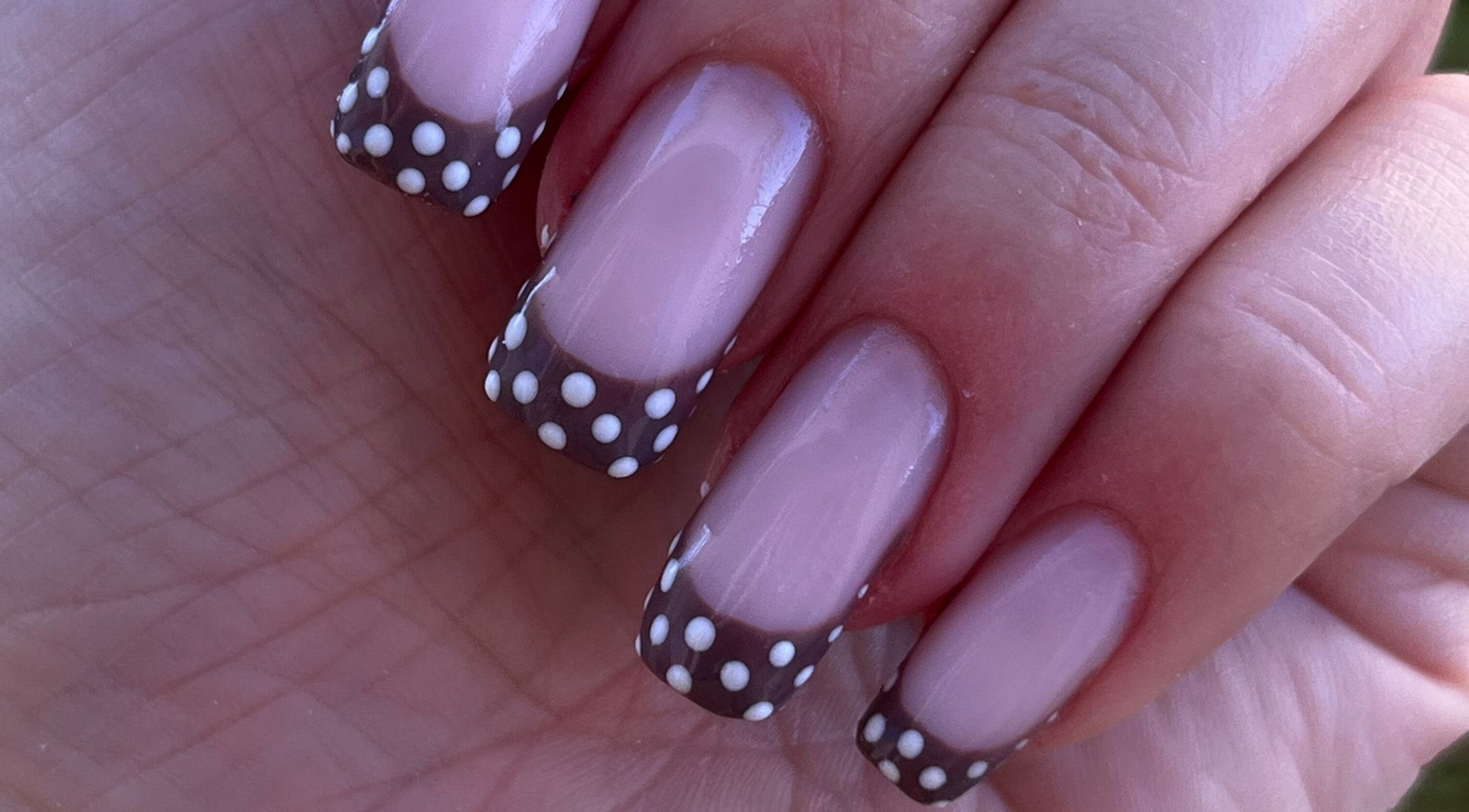 Nail art à pois noirs et blancs chez Dynails, Montmacq, Hauts-de-france, FR pour une touche élégante.